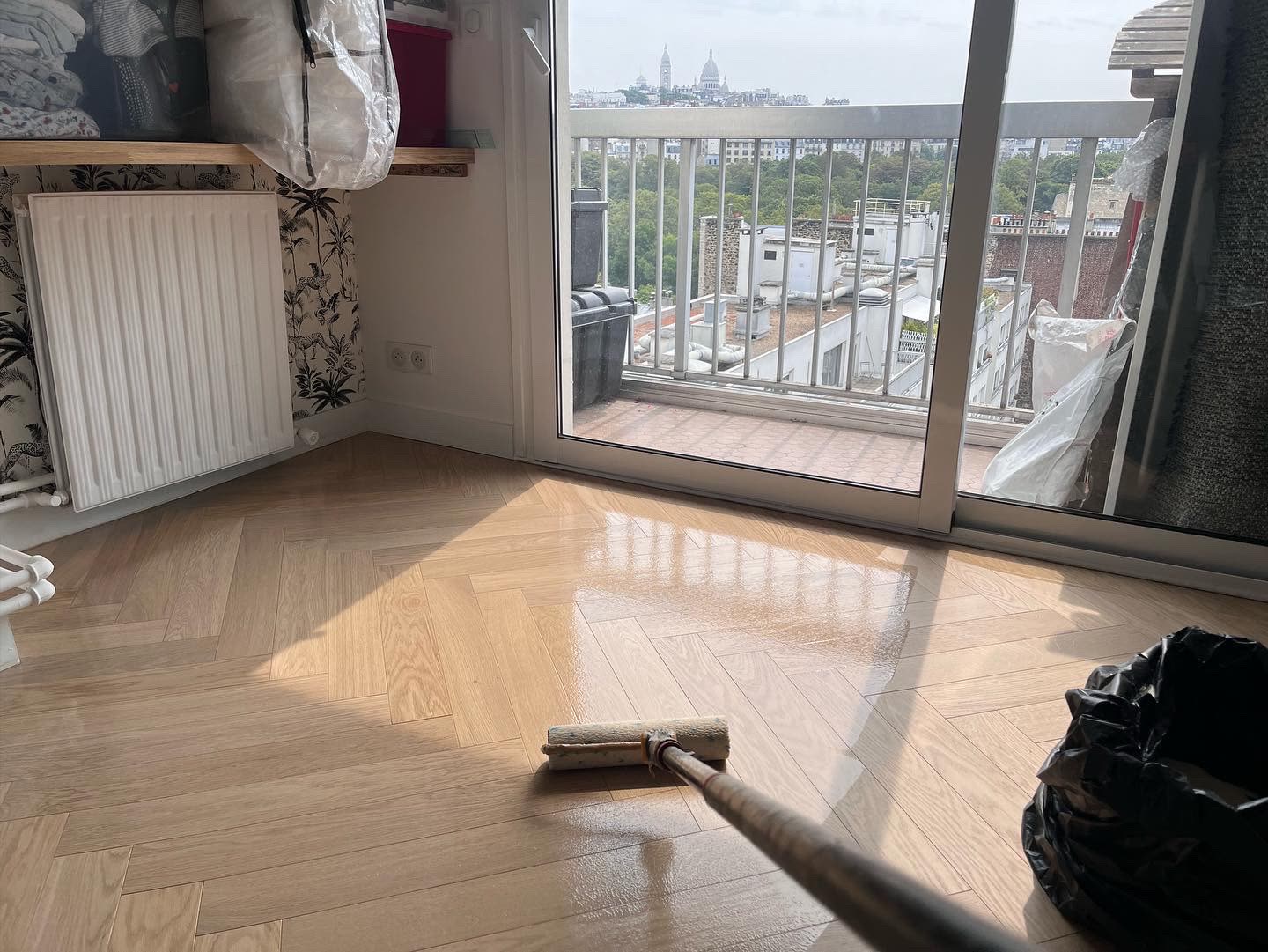 Application de la vitrification au rouleau sur un parquet fraîchement poncé