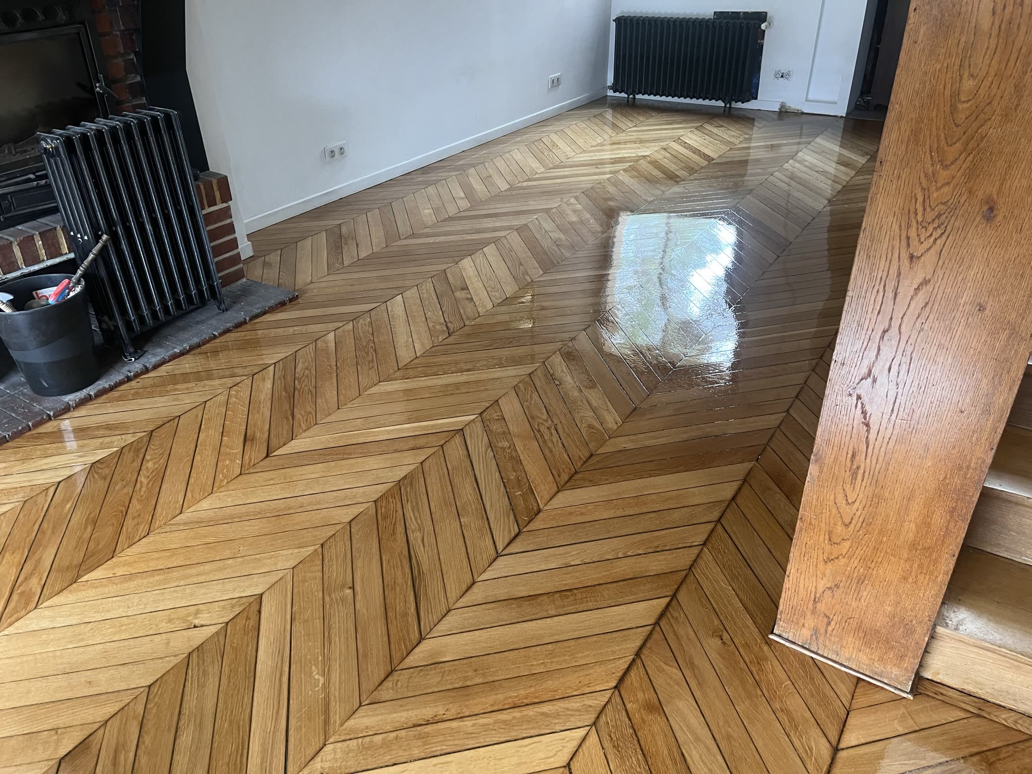 Cheminée en fonte et parquet point de Hongrie dans un séjour rénové