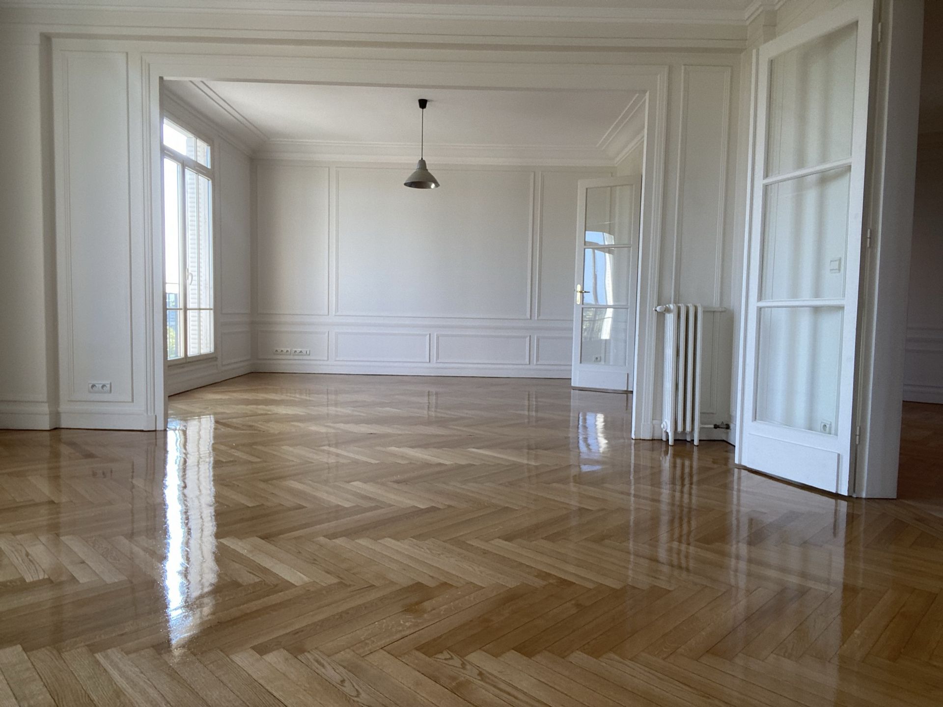 Parquet point de Hongrie vitrifié dans un séjour avec cheminée, rénové par Standing Travaux