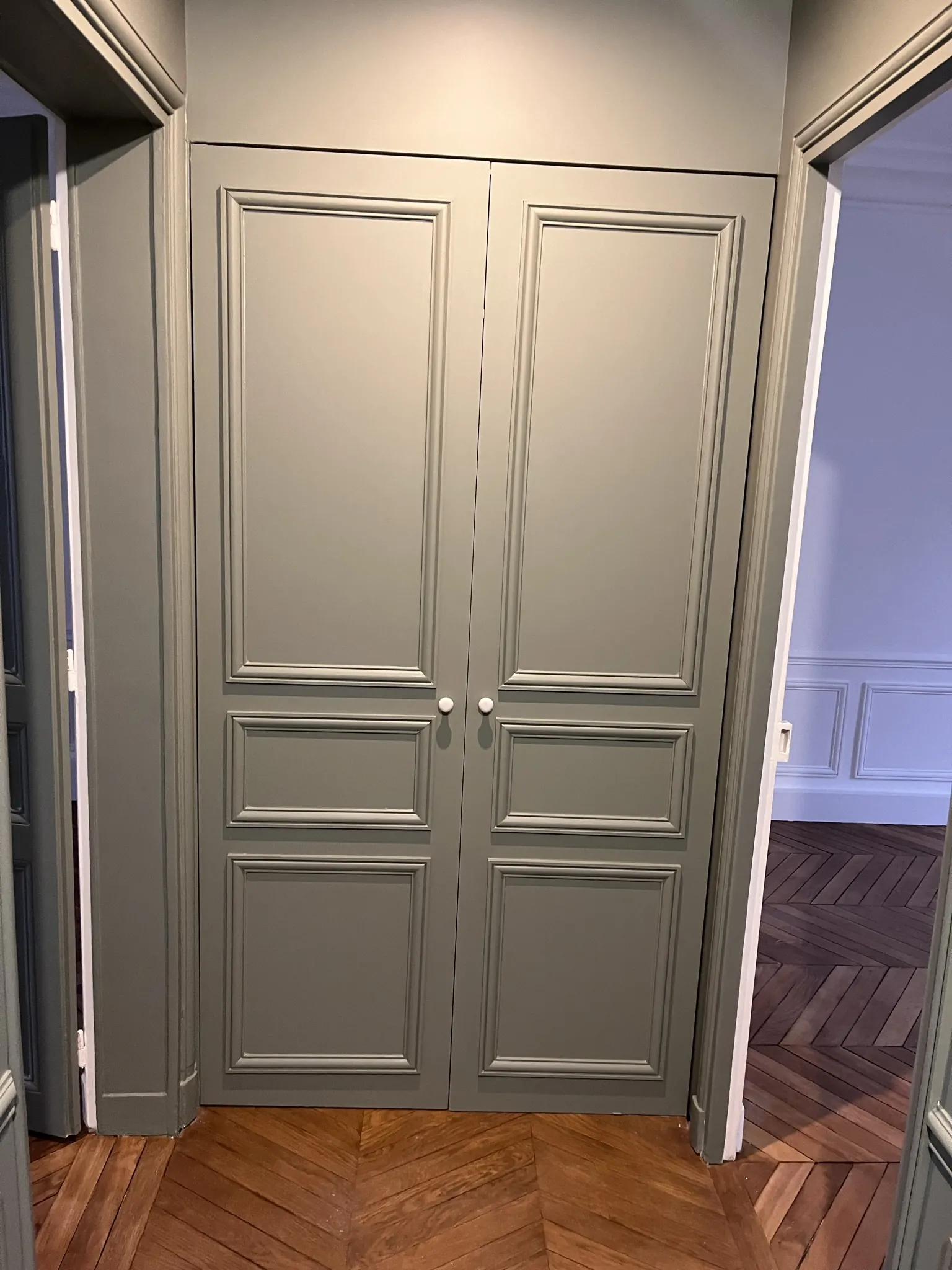 Double porte à moulures créée, montée et peinte en gris, ouvrant sur le parquet en chevrons rénové