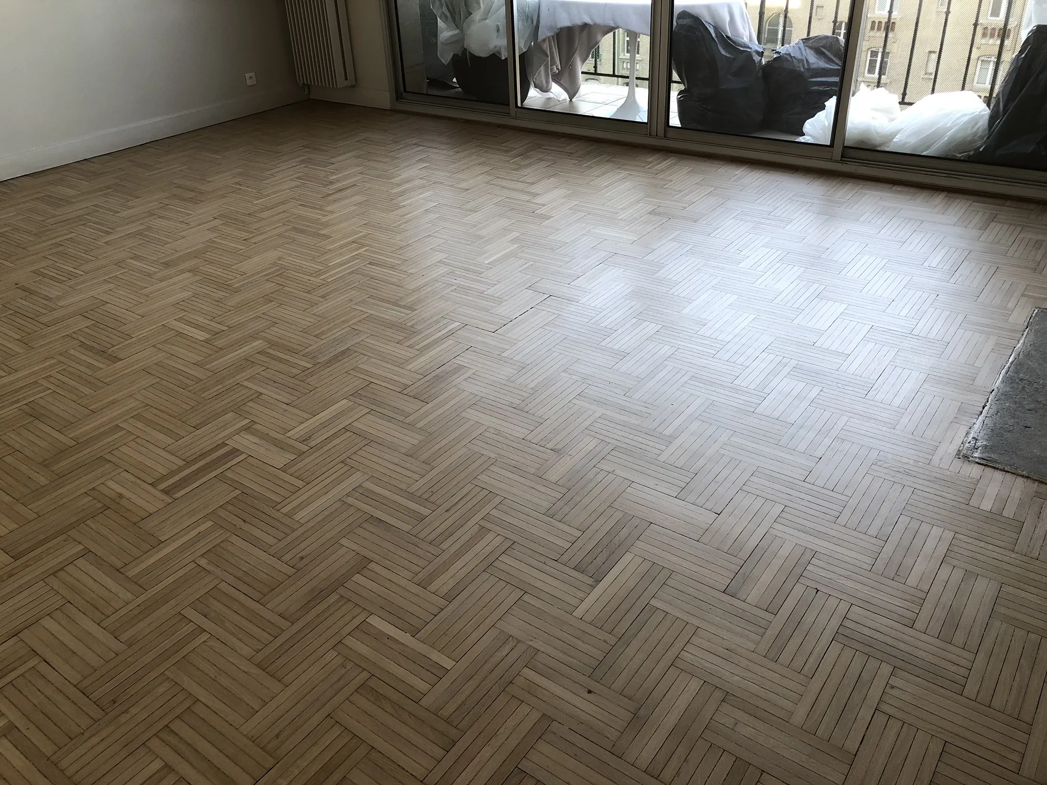Séjour vide avant travaux, parquet mosaïque grisé et terni