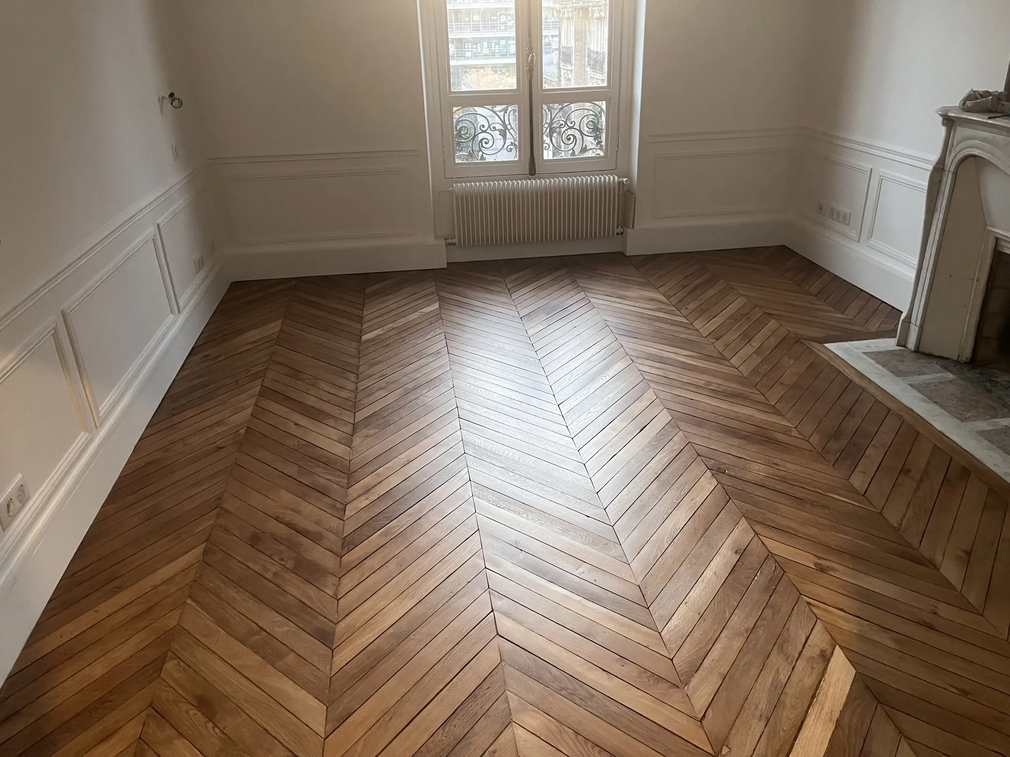 Salon haussmannien du 16e arrondissement, parquet point de Hongrie poncé et vitrifié, cheminée et murs moulurés