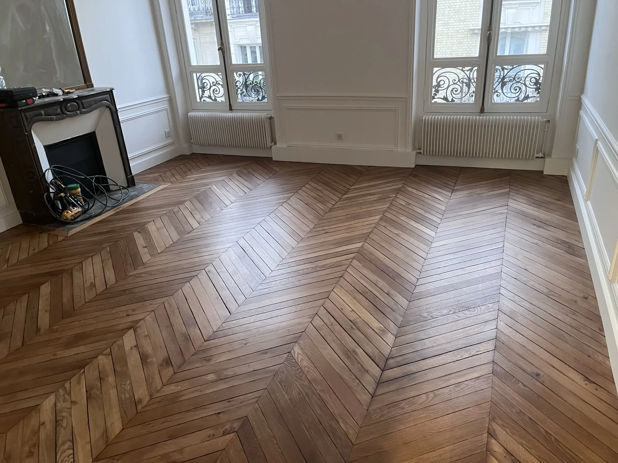Pièce haussmannienne du 16e avec cheminée en marbre, parquet point de Hongrie vitrifié