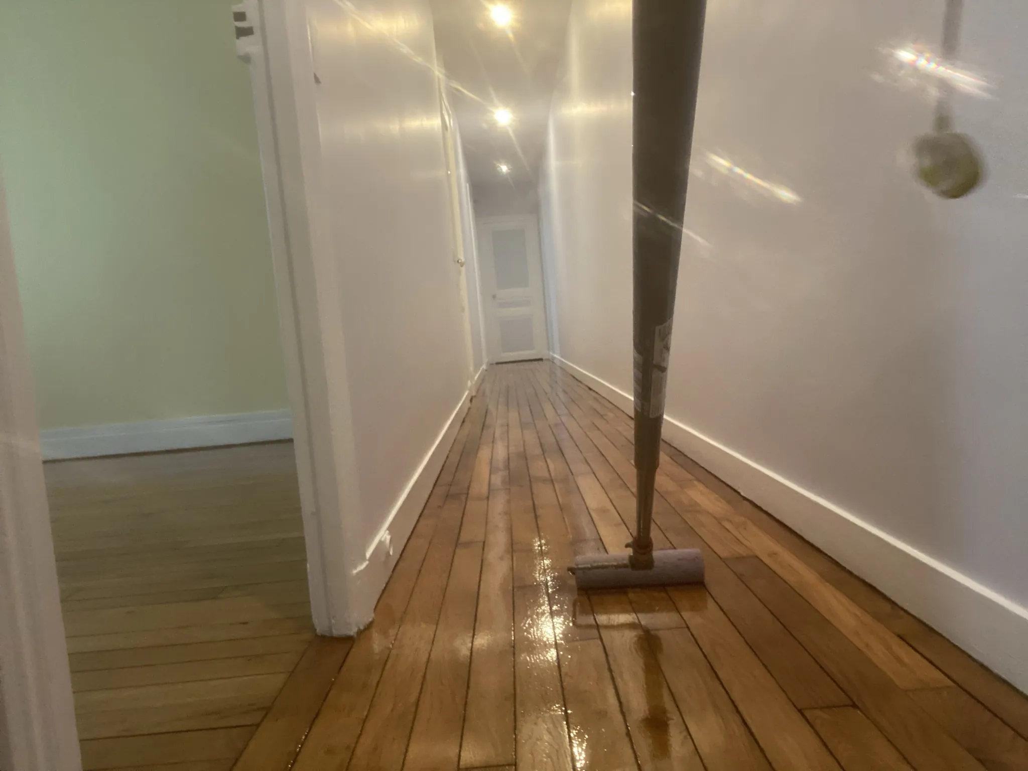 Application du vitrificateur au balai applicateur dans le couloir